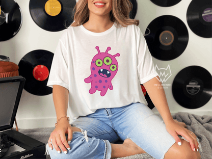 Woman wearing a white shirt featuring a pink alien creature against a wall with records.