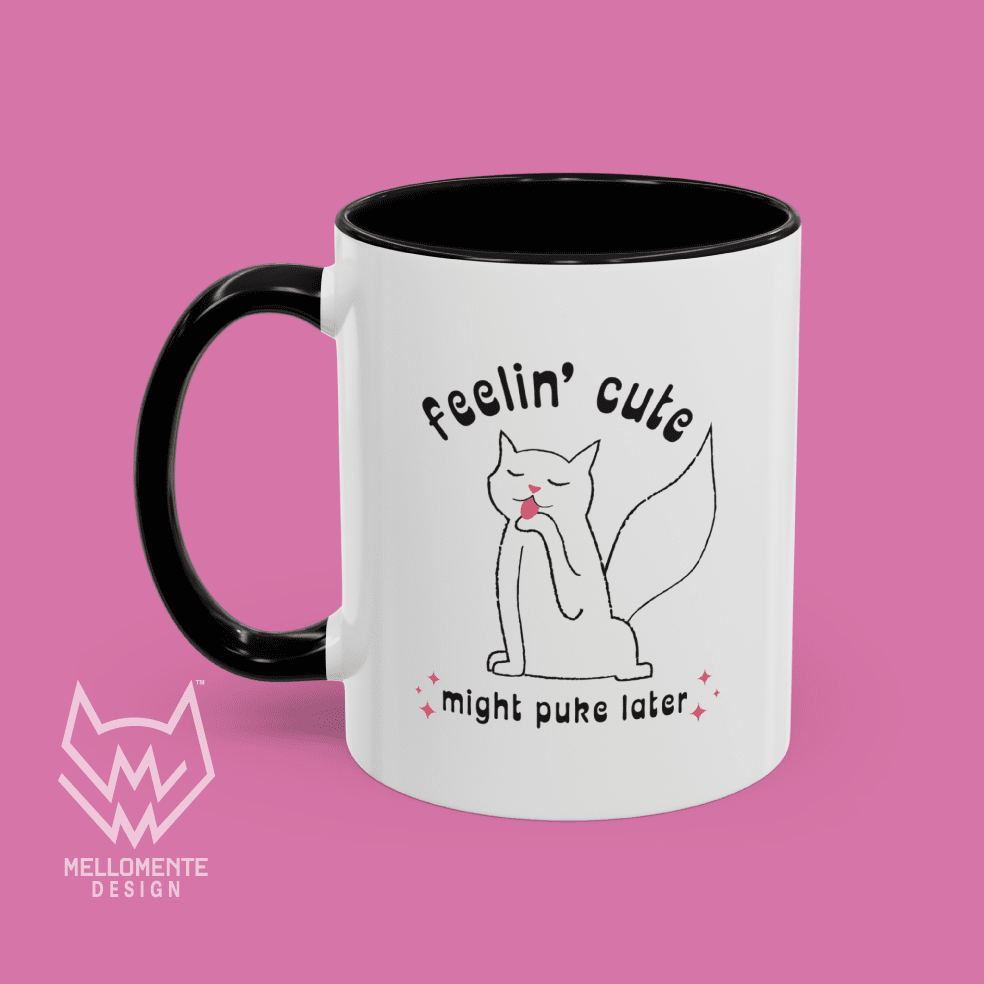 White mug with black interior featuring a cat illustration and text 'Feelin' cute might puke later' on a solid background.