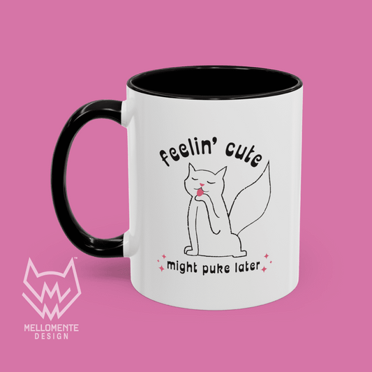 White mug with black interior featuring a cat illustration and text 'Feelin' cute might puke later' on a solid background.