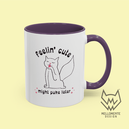 White mug with purple interior featuring a cat illustration and text 'Feelin' cute might puke later' on a solid background.