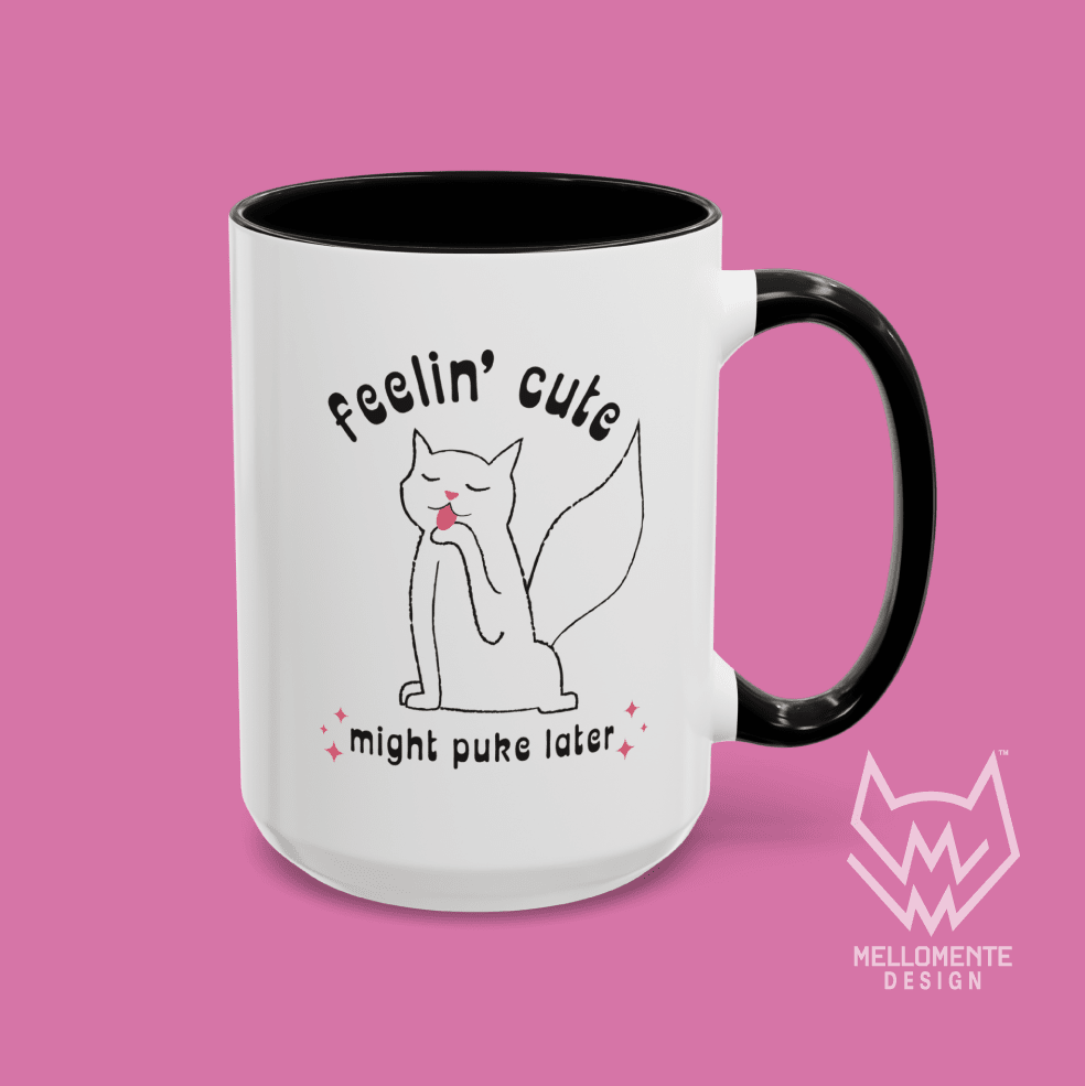 White mug with black interior featuring a cat illustration and text 'Feelin' cute might puke later' on a solid background.