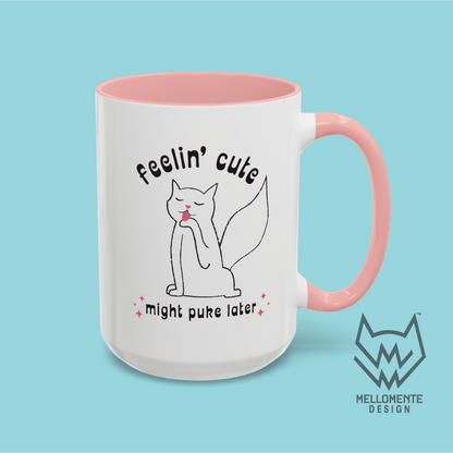 White mug with pink interior featuring a cat illustration and text 'Feelin' cute might puke later' on a solid background.