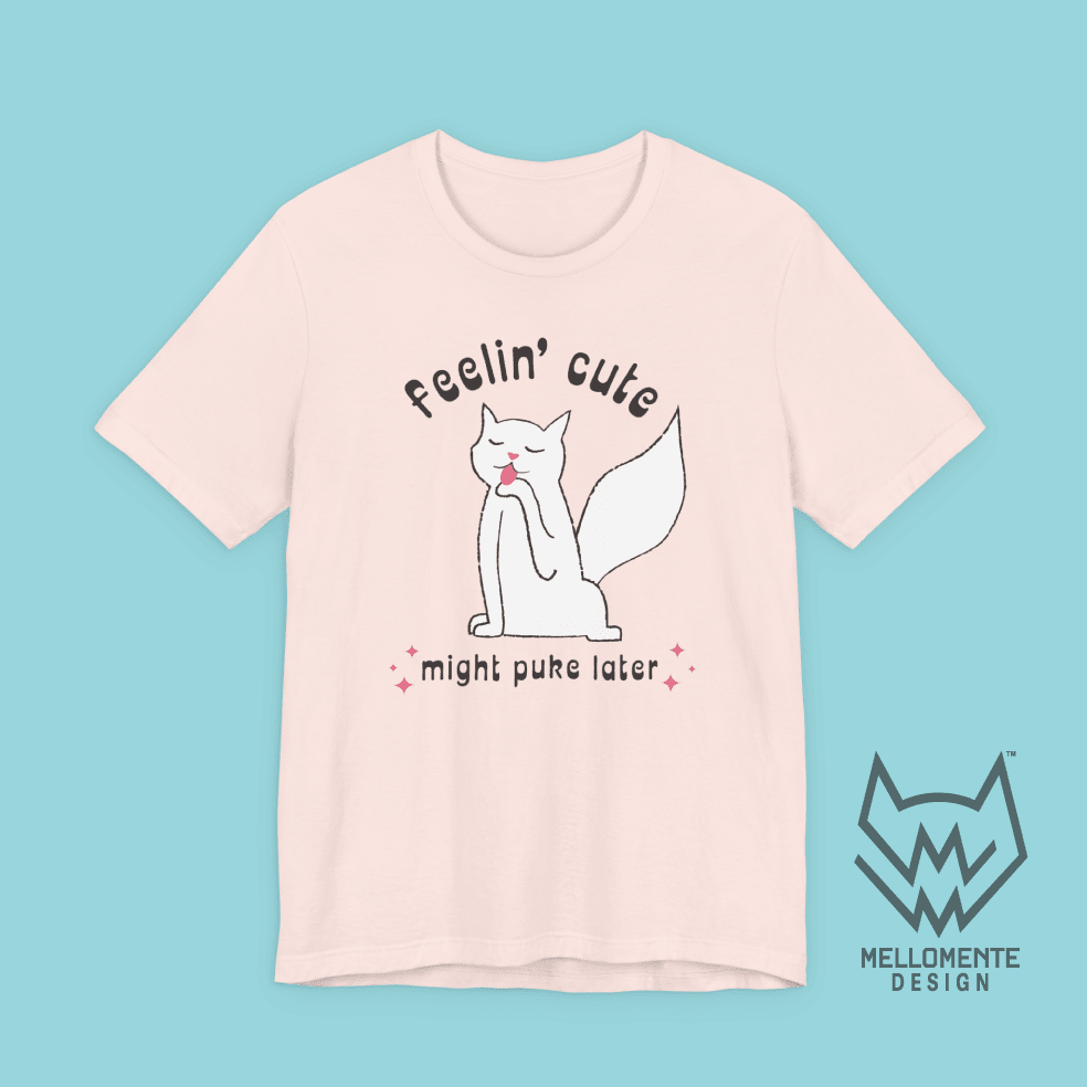 Pink t-shirt with a cat graphic and text on a solid background.