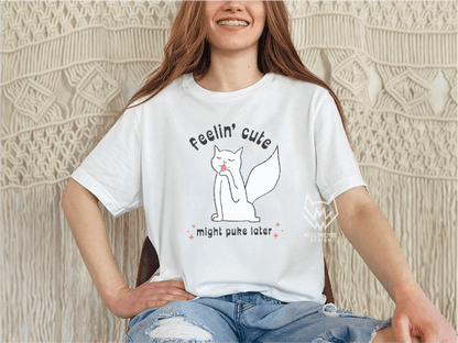 Person wearing a white t-shirt with a white cat graphic and text, sitting against a textured wall.