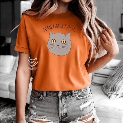 Person wearing an orange t-shirt with a cat graphic and text in a casual setting.